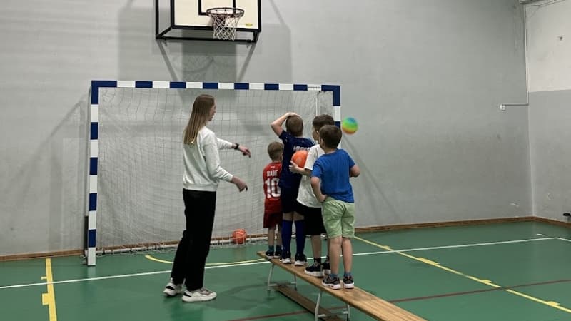 Instruktorka pomagająca dziecku, pokazująca indywidualne podejście